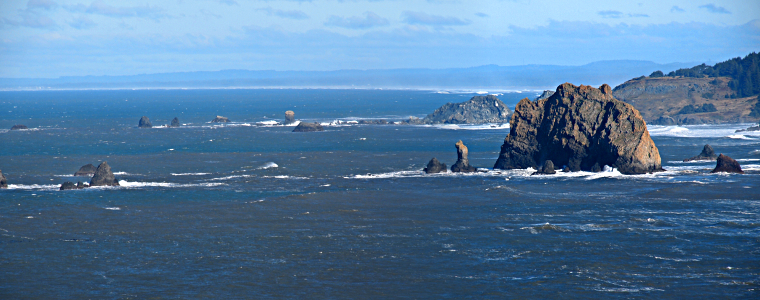 [Several photos stitched together showing the many varied-size rock outcroppings visible above the high tide water.]